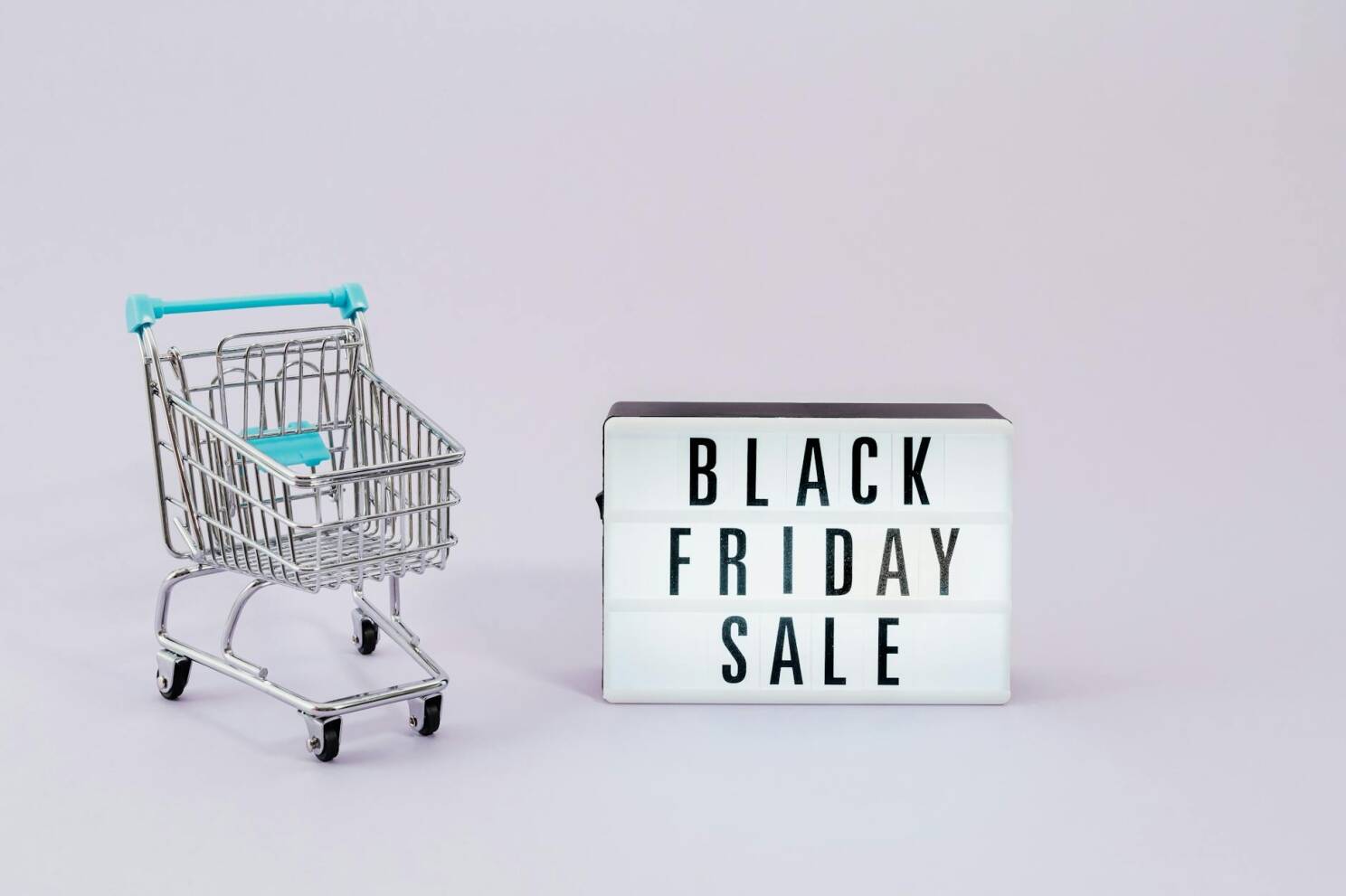 Minimalist image of shopping cart and Black Friday sale sign, perfect for retail promotions.